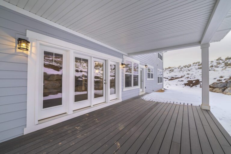 A vinyl deck is shown with one part of it covered in snow.