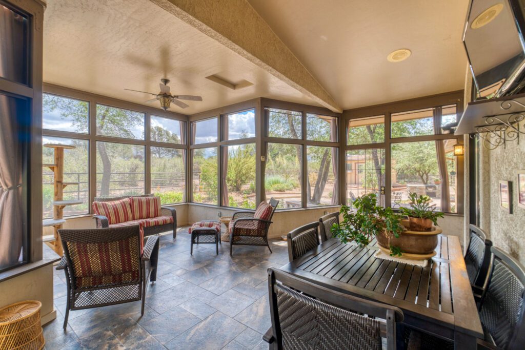 A screened-in deck has different areas for eating and sitting.