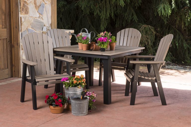 Outdoor furniture, four chairs and a table, sitting on a patio.